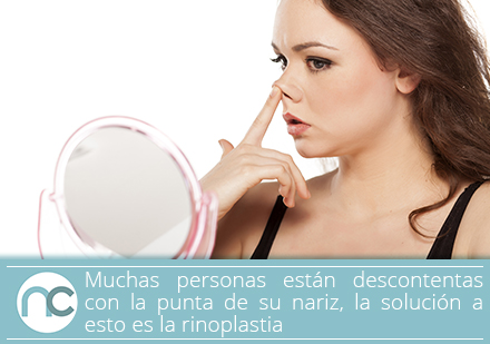 Un cirujano plástico de rinoplastia puede ayudarte a afinar la punta de tu nariz Mujer tocándose la punta de la nariz frente al espejo